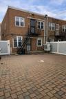Back of property featuring stairs and brick siding
