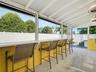 Screened in porch sitting area with bar