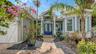 The paver driveway and walkway lead to a welcoming double French door entry