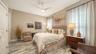 The second bedroom is located on the first floor, next to a hall bath, and features a walk-in closet with custom shelving