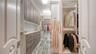 The large walk-in closet in the primary suite offers custom cabinetry and two separate areas for hanging clothes