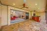 Lanai view of full outdoor kitchen and grill, showing living room with triple sliders