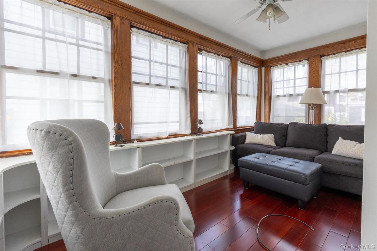 Wood-finish flooring with extensive window coverage featuring natural wood trim