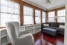 Wood-finish flooring with extensive window coverage featuring natural wood trim