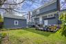 Expansive backyard featuring a manicured lawn, a detached storage shed with horizontal siding, and a multi-level deck