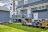 Expansive backyard featuring a manicured lawn, a detached storage shed, a multi-level wooden deck, and a blue retractable awning