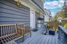 Exterior deck featuring painted wood flooring, painted wood railings, and a privacy fence