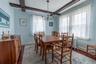 Dining area featuring exposed ceiling beams, wood-finish flooring, and multiple windows