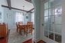 Dining area featuring exposed ceiling beams, a chandelier light fixture, wood-finish flooring, and an arched entryway