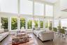 Living area with healthy amount of natural light, a high ceiling, and wood finished floors