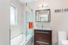 Bathroom with shower / bath combination with glass door and vanity