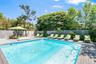 View of swimming pool with a fenced backyard and a deck
