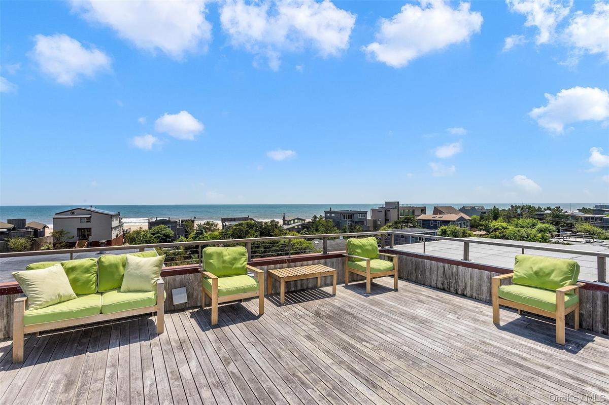 Wooden terrace featuring a water view and outdoor lounge area
