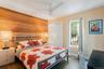 Bedroom featuring wood walls, dark wood-type flooring, a closet, and ceiling fan