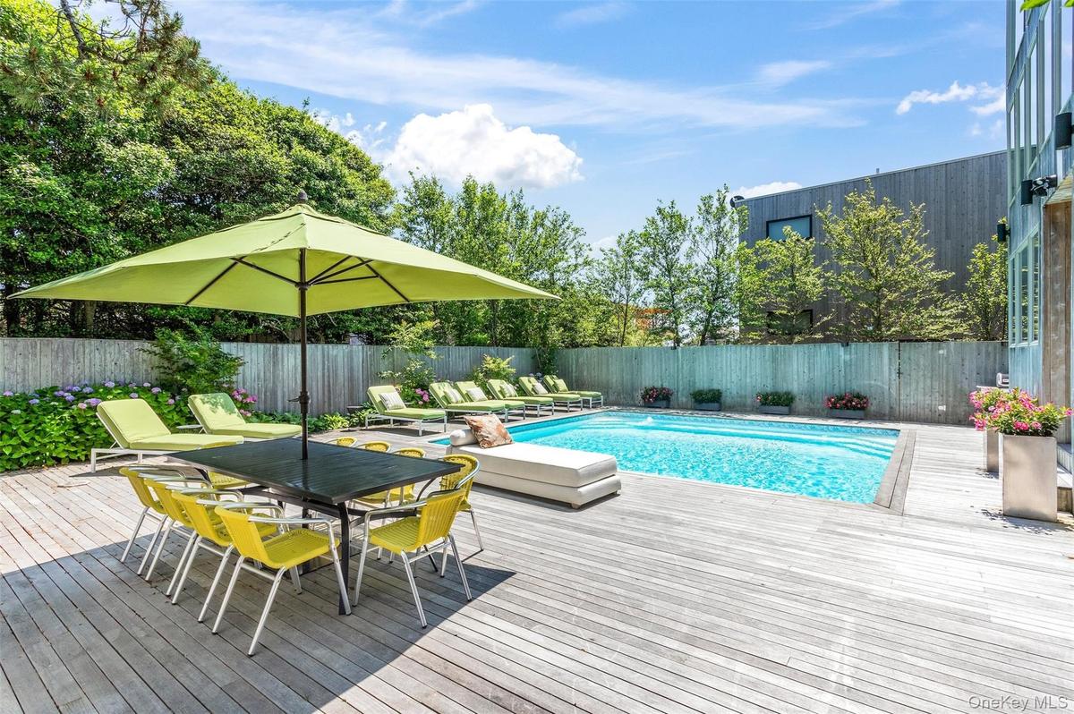 View of swimming pool with a fenced backyard, a deck, and outdoor dining space