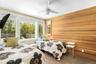 Bedroom featuring wooden walls, wood finished floors, and ceiling fan