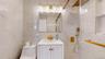 Bathroom featuring a white vanity with gold-tone hardware, a gold-tone faucet, and a mirrored medicine cabinet with integrated lighting