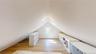 Loft space featuring sloped ceilings, light-tone wood-finish flooring, and white painted walls