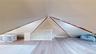 Loft space featuring sloped ceilings, light-tone wood-finish flooring, and white painted walls