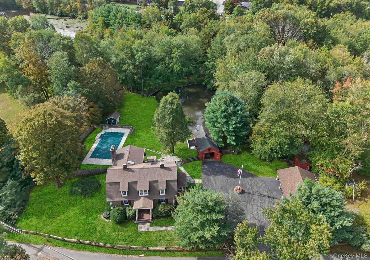 Aerial view of property's location with a pool area and beautiful private pond