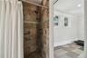 Ensuite gym area bathroom shower.  Opening to the right into the gym closes off with a barn door.