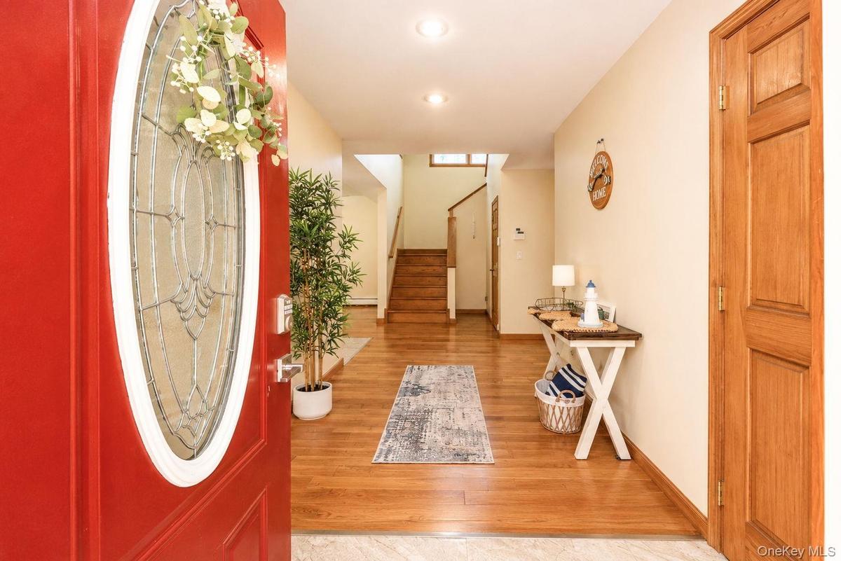 Spacious foyer with natural sunlight and hardwood floors~