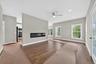 Another view of the open floor plan of the family room with hardwood flooring and the fireplace.