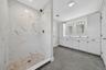 Separate tiled shower with double vanity.