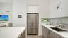 Contemporary kitchen with solid surface countertops and waterfall-edge island and SS appliances, including Miele induction range & Miele d/w, hood, an