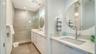 Modern bathroom with dual sinks and private toilet room provide bathing pleasure.