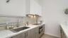 Roomy contemporary  bathroom with dual sinks and private toilet room.
