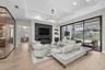 The great room is accented by wood beams, impressive chandeliers, gas fireplace, built-in cabinetry and oversized sliding glass doors that seamlessly 