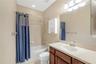 A full bathroom with a tub/shower combination is conveniently located in the hallway near the kitchen and family room, and is shared by two secondary 