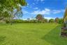 View from the lanai of the enormous park-like backyard, offering exceptional privacy enhanced by tall hedges.