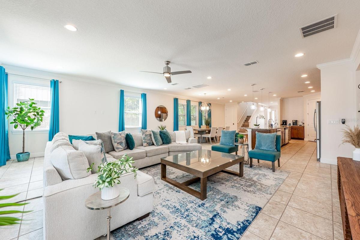 The expansive open-concept main floor seamlessly blends the Living Room, Dining area, and CHEF'S KITCHEN into one grand gathering space — ideal for ho