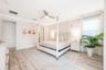 The main-level Primary Suite is a serene escape, showcasing LUXURY VINYL PLANK FLOORING, private sliding doors to the pool area, and a spa-inspired en
