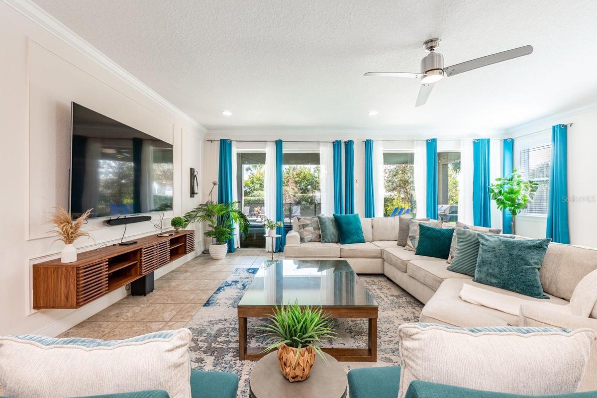 The Living Room features a striking picture-frame accent wall and sliding glass doors that open to your PRIVATE OUTDOOR OASIS.