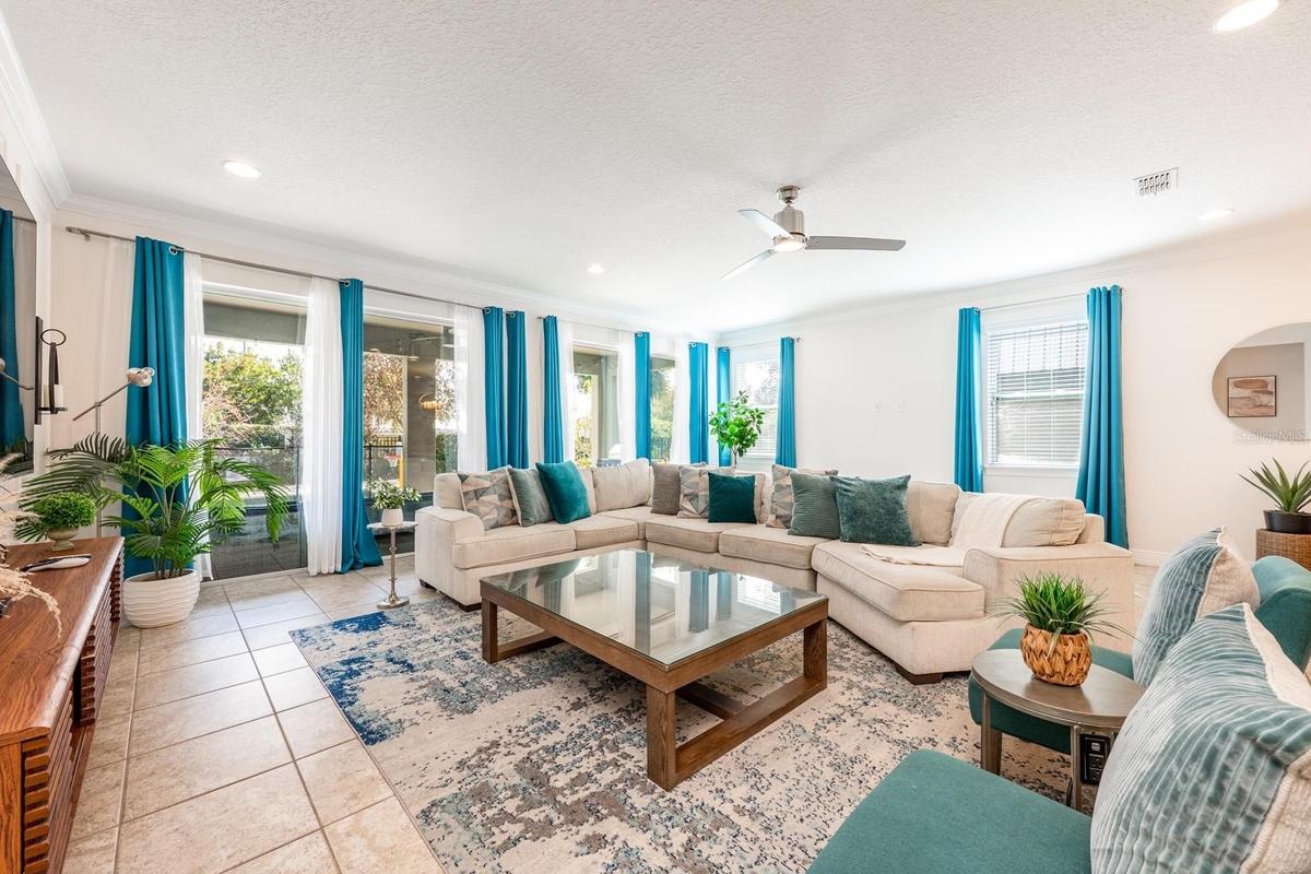 The Living Room features a striking picture-frame accent wall and sliding glass doors that open to your PRIVATE OUTDOOR OASIS.