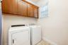 A WELL-EQUIPPED LAUNDRY ROOM with cabinetry for added convenience is located on the main floor.