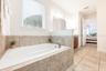 A spa-inspired en suite bath is complete with a GENEROUS WALK-IN CLOSET, dual sinks, garden tub, step-in shower, and private water closet.