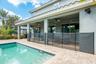 Step outside to the covered paver patio, where a SPARKLING PRIVATE POOL and SPA await, designed for relaxation and entertainment.