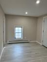 Unfurnished room with light wood-style floors, baseboard heating, and recessed lighting