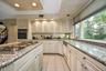 Kitchen with light stone countertops, recessed lighting, stainless steel gas cooktop, black oven, and light tile patterned floors