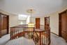 Hallway with a skylight, an upstairs landing, carpet floors, and a chandelier