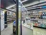 Secure Glass-Enclosed Sales Counter with Controlled-Access Door and Premium Liquor Display