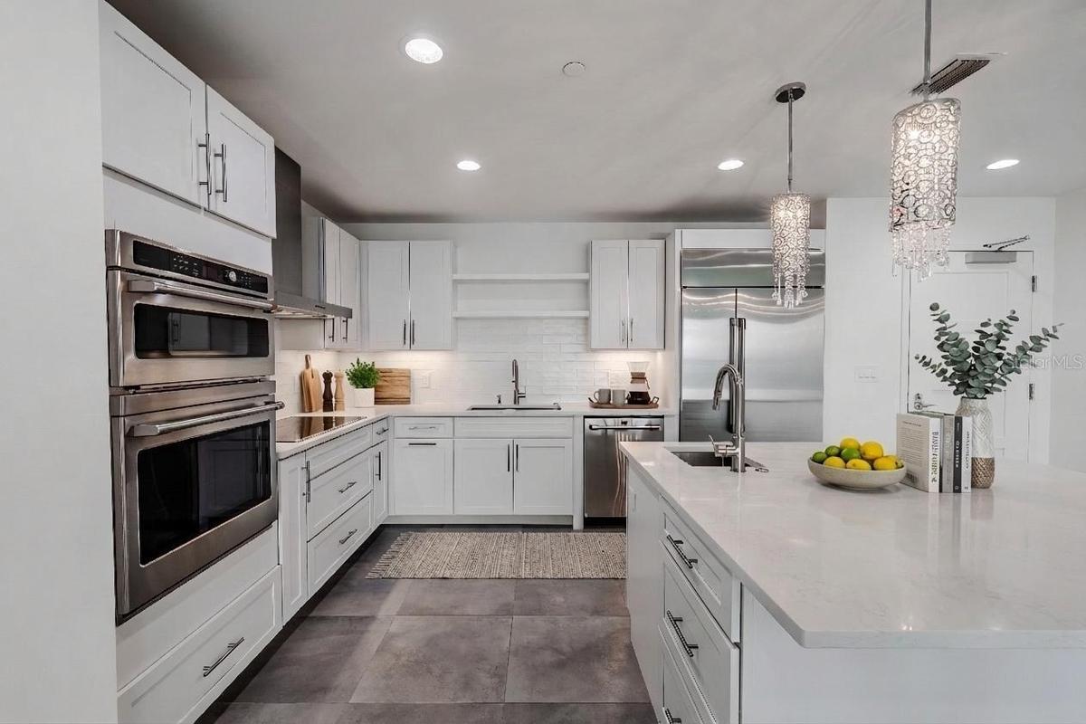 This sophisticated, all-white kitchen exudes modern elegance with its clean lines and luxury finishes.