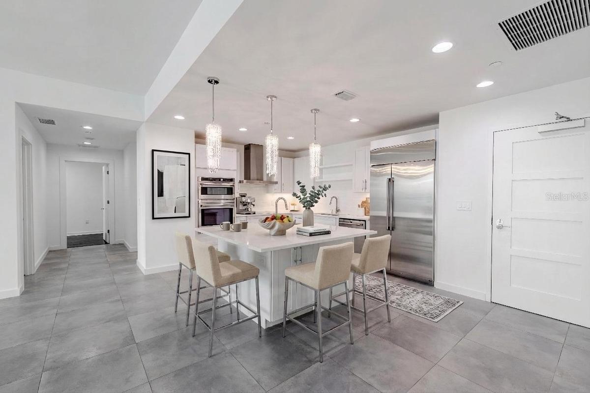 This show stopping modern kitchen is the centerpiece of the home, designed for both style and functionality. A sleek quartz island with storage and si
