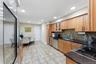Kitchen featuring wood cabinetry, dark countertops, a mosaic tile backsplash, stainless steel appliances, and tile flooring