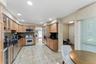 Kitchen featuring wood cabinetry, dark countertops, tiled backsplash, and stainless steel appliances