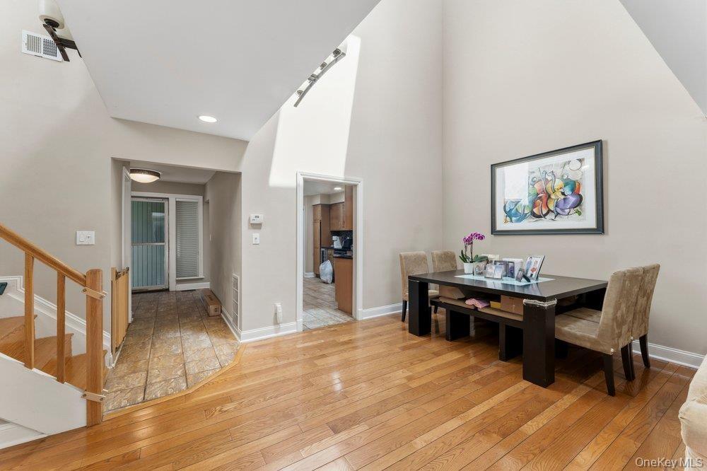 Hardwood flooring extending through the primary living area, complemented by a soaring vaulted ceiling